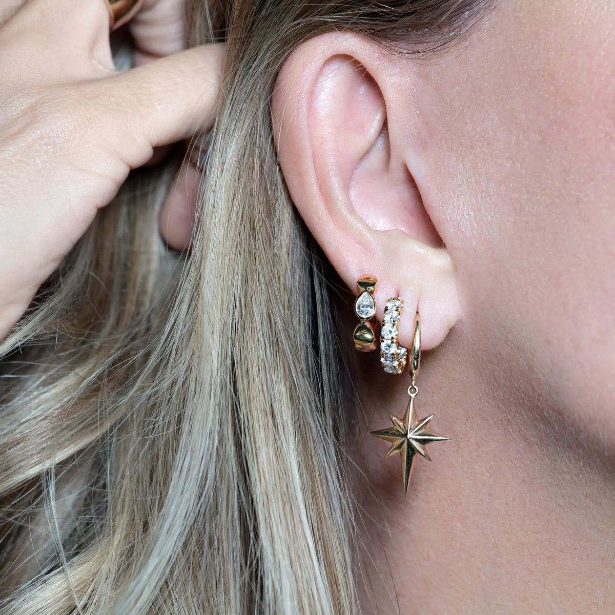 North Star Huggie Earrings in 14K Yellow Gold, on ear | JJ Jewelry Miami