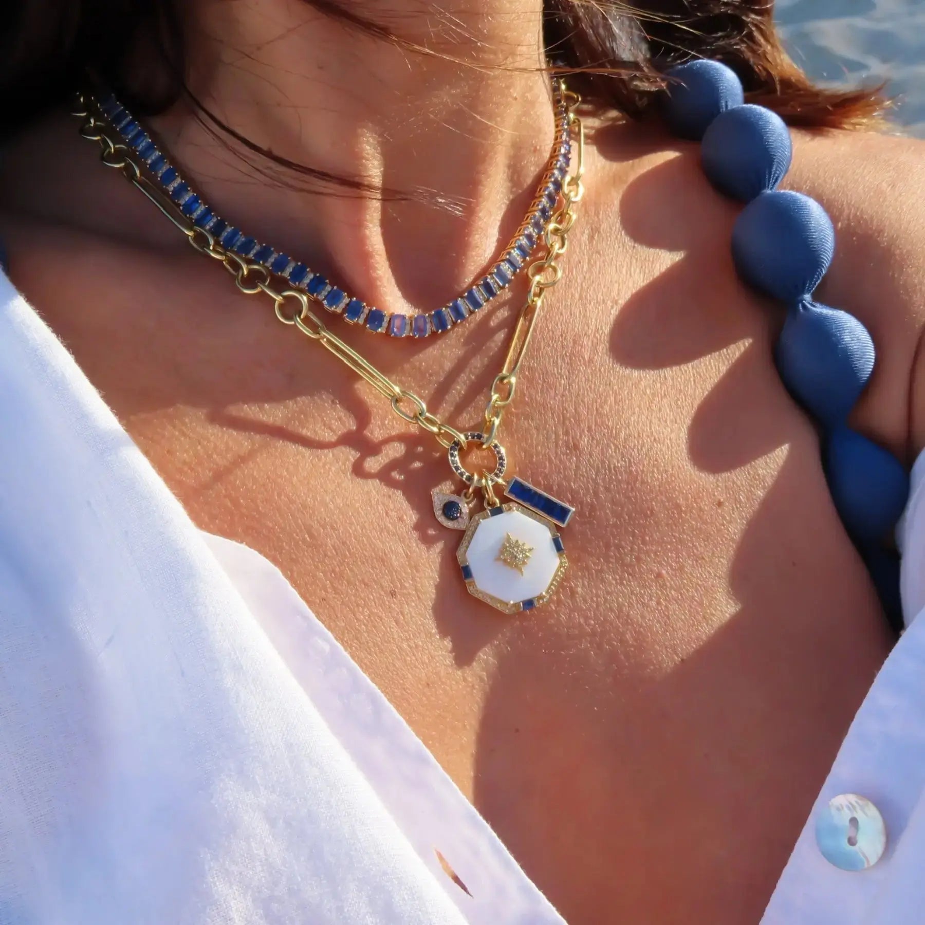 Celestial starburst pendant in yellow gold featuring sapphires and diamonds